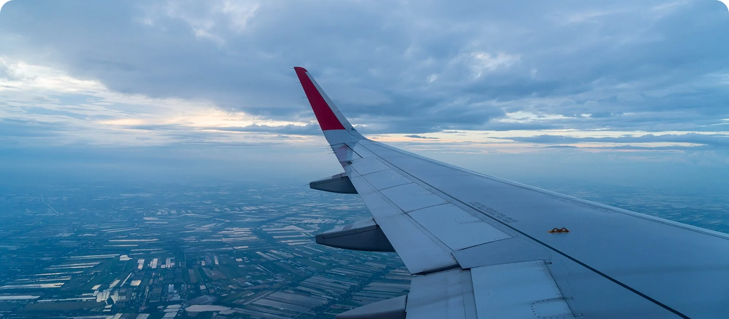 Airplane wing over clouds